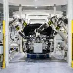 High-tech robots assembling a car in a modern factory setting, showcasing automation.